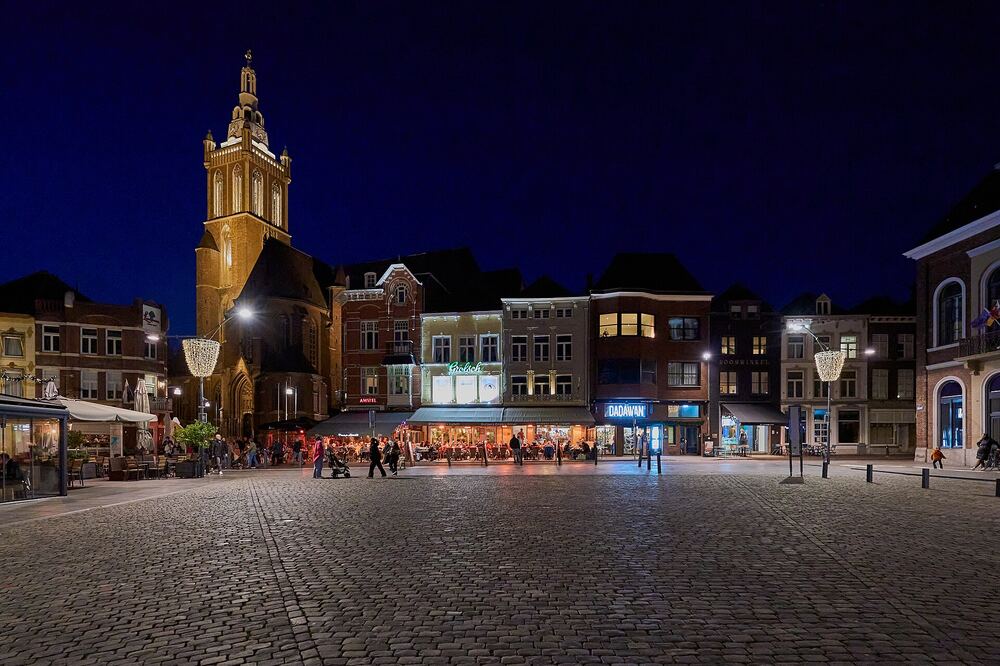 De Markt van Roermond met verlichte terrassen in de avond